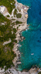 Zakynthos Greece Blue Caves aerial photo showing turquoise Ionian Sea rocky cliffs boats by the coast and windmill landmark close to shoreline