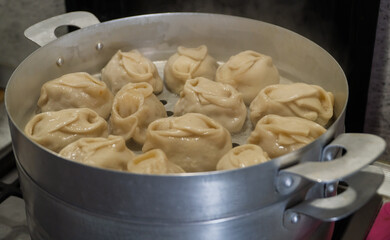 Delicious Manty, posture, khinkali is prepared in a special pot - mantoverde. Dishes of Asian,...