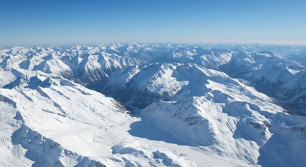 Aerial view of snow-covered mountain range under clear blue sky