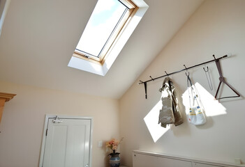 Sunlit Attic Room with Clothes Hanging on a Rail