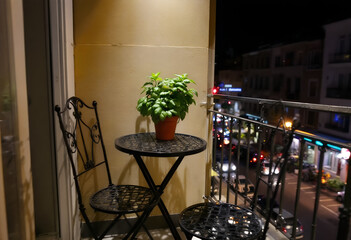 Nighttime Balcony Scene with City Lights and Potted Plant