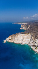 Aerial photo of Plakaki beach Zakynthos Greece showing steep limestone cliffs turquoise coves deep ocean water and dry hills under clear sky