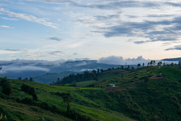 Obraz premium Mountains with green trees and evening light 