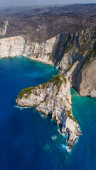 Aerial photo of Plakaki beach Zakynthos Greece showing steep limestone cliffs turquoise coves deep blue ocean and dry rocky hills above coast