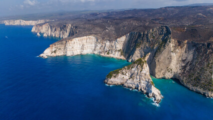 Plakaki beach Zakynthos Greece dramatic aerial view with sheer cliffs turquoise bays rocky headland and endless Ionian Sea under clear blue sky