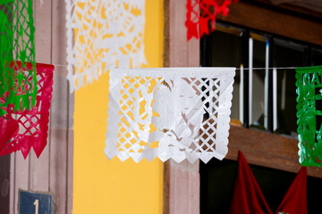 A white paper with a woman's face drawn on it is hanging from a string. Historic center of Queretaro City, decorations and traditions to celebrate Mexico's Independence Day, colonial architecture, all
