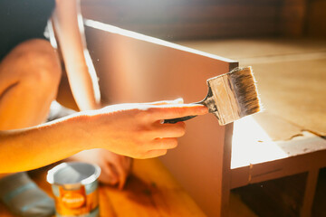 Fototapeta premium A person is painting a piece of furniture