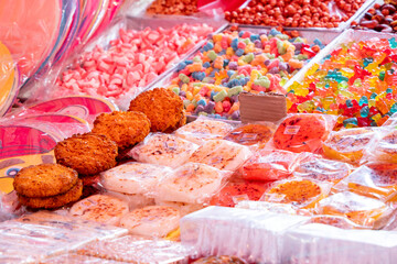 A table full of mexican candies and snacks. The candy is colorful and there are many different types. Historic center of Queretaro City, decorations and traditions to celebrate Mexico's Independence D