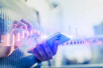 Woman with smartphone in hands, abstract business graphs and digital world map behind.