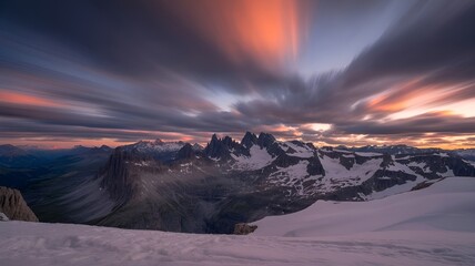 A majestic mountain range stretches under a dramatic sky with streaks of clouds.