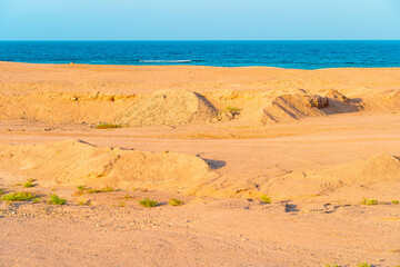 Coast Egypt with desert sands and view towards turquoise sea at sunset, Marsa Alam, African coast.