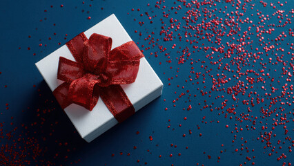 Elegant Red Ribbon Gift Box on Glitter Background for Christmas and Holiday Celebrations