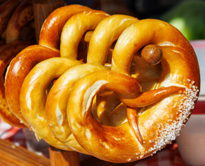 A row of pretzels are hanging on a wooden rack