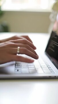 Ultra close-up of confident hands typing legible code on a sleek, modern laptop keyboard with soft bokeh, showcasing efficient progress.