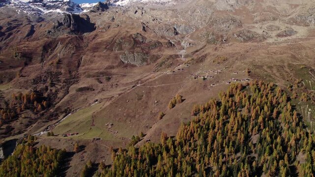 Drone shot of a mountain with yellow conifer trees in autumn, L&ouml;tschental, Switzerland