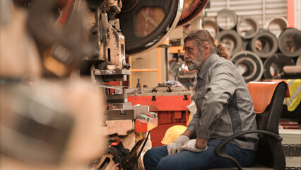 Senior experienced technician checking and maintenance a large machine