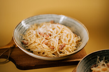 Pasta bolognese served in a rustic bowl with a simple wooden serving board