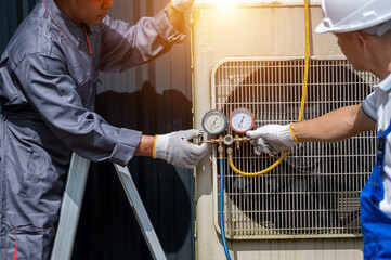 HVAC Repair and Maintenance: A pair of skilled technicians meticulously inspect and service an air conditioning unit, expertly utilizing gauges to ensure optimal performance and efficiency.