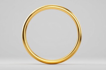 A thick, golden ring rests on a light grey surface