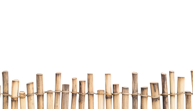 A rustic wooden fence made of bamboo sticks stands against a plain white background. creating a serene and minimalist aesthetic ideal for nature-themed projects or home decor