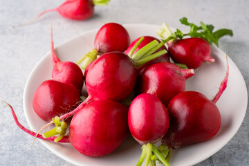 Fresh small red radishes on vintage stone table background