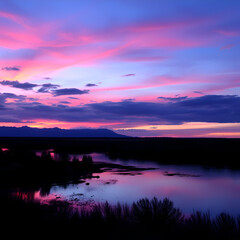 Obraz premium Serene Sunset Landscape: Vibrant Pink and Blue Colors Reflecting on Tranquil Waters