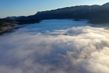 Aerial view of autumn morning mist and clouds in the valley