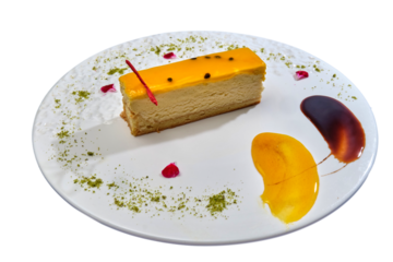 Slice of cheesecake with glossy glaze and butterfly decor on a plate with artistic sauce presentation and sprinkled garnish.