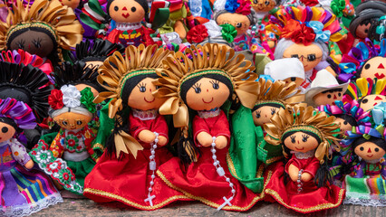A collection of dolls with different colors and designs. The dolls are arranged in a row. Historic center of Queretaro City, decorations and traditions to celebrate Mexico's Independence Day, colonial
