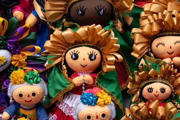 A collection of dolls with colorful clothing and accessories. The dolls are arranged in a row. Historic center of Queretaro City, decorations and traditions to celebrate Mexico's Independence Day, col