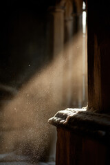 delicately falling snowflakes shimmer in bright beam of light gently illuminating ancient church