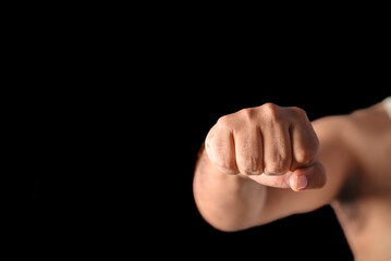 Close-Up of a Fist in a Black Background Symbolizing Strength and Power