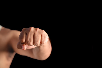 Close-Up of a Fist in a Black Background Symbolizing Strength and Power