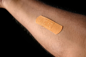 Close-Up of Bandage on an Arm with Dark Background