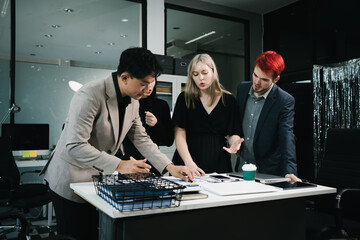 Four colleagues engage in a collaborative office meeting, using laptops, tablets, and documents to brainstorm ideas, discuss strategies,share insights, fostering teamwork, productivity, professional