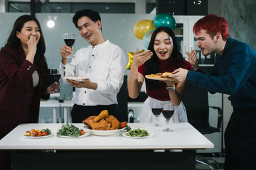 Four cheerful friends celebrate together in an office party, enjoying delicious food, fried chicken, pizza, salad, wine. Surrounded by balloons and laughter, they share happiness, marking   year-end