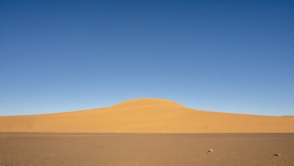 A vast sand dune under a blue sky