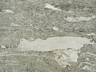 Granite-like Stone Surface with Rough Texture and Lighter Inclusions, close-up. Copyspace.