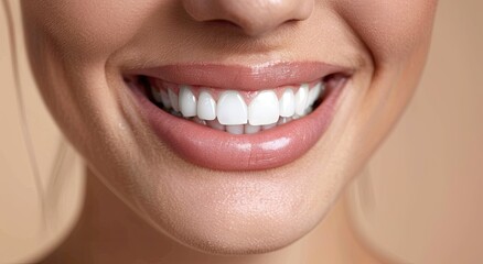Obraz premium Close-up of a woman's bright, healthy smile against a neutral background. The image showcases flawless teeth and full, glossy lips