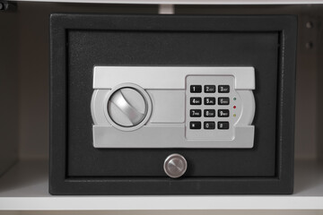 Modern safe on shelf in room, closeup