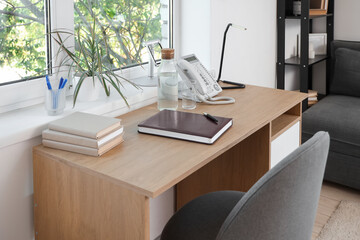 Comfortable workspace near window in modern living room