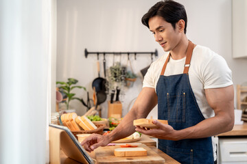 Asian man cooking healthy foods in cozy kitchen in morning at home. 