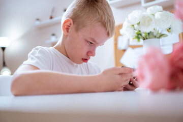A boy with hearing aids engages with a smartphone, playing mobile games with focused enjoyment....