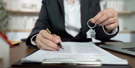 Lawyer holding house key and signing real estate contract