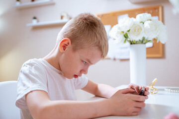 A boy with hearing aids engages with a smartphone, playing mobile games with focused enjoyment....