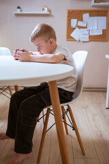 A boy with hearing aids engages with a smartphone, playing mobile games with focused enjoyment....