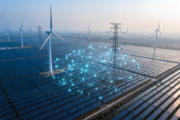 Aerial view of solar panels and wind turbines with digital network overlay representing renewable energy integration