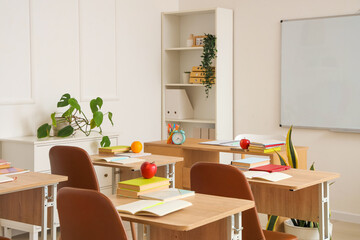 Interior of empty classroom with school desks and clean whiteboard