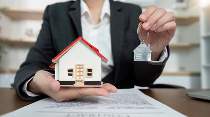 Lawyer holding house model and key over real estate contract