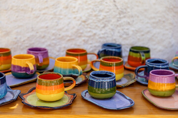 colorful ceramic cups on wooden table retale outdoors